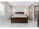 Spacious bedroom featuring a large bed, tile flooring, and ensuite bathroom with sliding barn door at 22901 E Quintero Rd, Queen Creek, AZ 85142