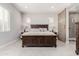 Primary bedroom featuring a large wooden bed frame, bedside tables, barn door to bathroom, and tile flooring at 22901 E Quintero Rd, Queen Creek, AZ 85142