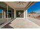 Covered patio with ceiling fan and sliding glass doors leading to a landscaped backyard and a clear blue sky at 22901 E Quintero Rd, Queen Creek, AZ 85142