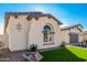 Exterior view of a modern single-story home featuring an arched window, manicured lawn, and an attached garage at 22901 E Quintero Rd, Queen Creek, AZ 85142