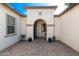 Charming front porch with arched entryway, potted plants, and a rocking chair for relaxation at 22901 E Quintero Rd, Queen Creek, AZ 85142