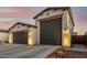 Spacious three-car garage with gray doors and decorative exterior lighting at 22901 E Quintero Rd, Queen Creek, AZ 85142