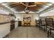 Well-lit outdoor kitchen with stainless steel grill, bar seating, and television at 22901 E Quintero Rd, Queen Creek, AZ 85142