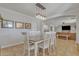 Dining room features a wood table, white chairs, and an open concept to the living room at 2344 N Raven --, Mesa, AZ 85207