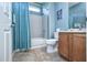 Clean bathroom with teal shower curtain, wood vanity and tile floors at 26175 W Firehawk Dr, Buckeye, AZ 85396