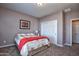 Bedroom with double bed, red blanket, and carpeted floors at 26175 W Firehawk Dr, Buckeye, AZ 85396