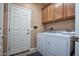 Laundry room with washer, dryer, and extra cabinets at 26175 W Firehawk Dr, Buckeye, AZ 85396