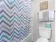 Clean bathroom with a chevron-pattern shower curtain and updated toilet at 2626 E Bear Creek Ln, Phoenix, AZ 85024