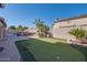 Beautiful backyard with a putting green and built-in BBQ, surrounded by desert landscaping and palm trees at 2848 E Menlo St, Mesa, AZ 85213