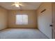 A neutral bedroom with a window providing natural light and plush carpeting at 2848 E Menlo St, Mesa, AZ 85213