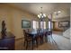 Elegant dining area featuring a large table, chandelier, and window with plantation shutters at 2848 E Menlo St, Mesa, AZ 85213