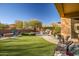 Landscaped backyard with artificial turf, fire pit, and patio area at 30224 N 52Nd Pl, Cave Creek, AZ 85331