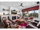 Spacious living room with a fireplace, large windows, and comfortable leather furniture at 30224 N 52Nd Pl, Cave Creek, AZ 85331