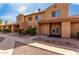 Tan two-story condo building with double door entry and small landscaping at 3511 E Baseline Rd # 1210, Phoenix, AZ 85042