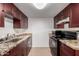 Galley kitchen with dark wood cabinets and granite counters at 3511 E Baseline Rd # 1210, Phoenix, AZ 85042