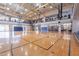 Spacious indoor gymnasium with hardwood flooring, basketball hoops, and a large mezzanine overlooking the court at 3703 W Mccauley Ct, Phoenix, AZ 85086