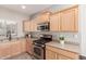 Kitchen features gas range, microwave, and light wood cabinets at 3703 W Mccauley Ct, Phoenix, AZ 85086