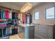 Luxurious closet with custom shelving, hanging space, and a center island at 41104 N 96Th St, Scottsdale, AZ 85262