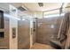 Large walk-in shower with multiple shower heads and a built-in bench at 41104 N 96Th St, Scottsdale, AZ 85262