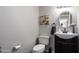 Simple and clean bathroom with a vanity, toilet, and oval mirror at 4240 N 67Th Ln, Phoenix, AZ 85033