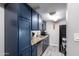 Efficient galley kitchen with dark blue cabinets and granite countertops at 4240 N 67Th Ln, Phoenix, AZ 85033