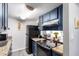 Modern kitchen with dark blue cabinets, granite counters, and a cooktop at 4240 N 67Th Ln, Phoenix, AZ 85033