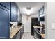 Galley kitchen with dark blue cabinetry, granite countertops, and black appliances at 4240 N 67Th Ln, Phoenix, AZ 85033