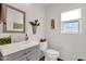 Small bathroom with gray vanity, toilet, and decorative wall accents at 43579 W Arizona Ave, Maricopa, AZ 85138