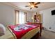 Bedroom with a full-size bed, bookcase, and ceiling fan at 43579 W Arizona Ave, Maricopa, AZ 85138