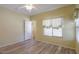 Spacious bedroom with wood-look floors and a window with curtains at 45091 W Cypress Ln, Maricopa, AZ 85139