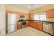 Kitchen features stainless steel appliances and wood cabinets at 45091 W Cypress Ln, Maricopa, AZ 85139