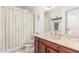 Main bathroom with striped shower curtain and wood vanity at 5210 W Ironwood Dr, Glendale, AZ 85302