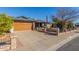 Brick house with a wooden garage door, neat landscaping, and a flag displayed at 5210 W Ironwood Dr, Glendale, AZ 85302