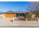 House exterior featuring a brown garage door, brick accents, and a manicured lawn at 5210 W Ironwood Dr, Glendale, AZ 85302