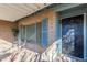 Covered front porch with a small table and chairs, blue shutters, and a black door at 5210 W Ironwood Dr, Glendale, AZ 85302