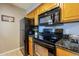 Modern kitchen with black appliances and granite countertops at 5877 N Granite Reef Rd # 2224, Scottsdale, AZ 85250