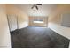 Large carpeted bedroom with neutral walls, ceiling fan, and a window at 6102 S 37Th Ln, Phoenix, AZ 85041