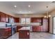 Kitchen with stainless steel appliances, dark wood cabinets, tile floors, and an island at 6102 S 37Th Ln, Phoenix, AZ 85041