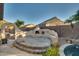 Unique stucco fire pit with raised seating and mountain backdrop at 6233 W Maya Dr, Phoenix, AZ 85083