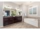 Elegant bathroom with double sinks, a soaking tub, and dark wood cabinets at 6251 E Bramble Berry Ln, Cave Creek, AZ 85331