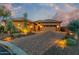 Evening view of single story home with welcoming landscaping and driveway at 6251 E Bramble Berry Ln, Cave Creek, AZ 85331