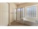 Bathroom featuring a glass-enclosed shower, soaking tub, and neutral color palette at 638 W Nido Ave, Mesa, AZ 85210