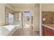 Bathroom featuring a garden tub with a glass shower, a window, and tile flooring at 638 W Nido Ave, Mesa, AZ 85210