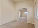 A bright bedroom with neutral carpet and a wide doorway leading to the next room at 638 W Nido Ave, Mesa, AZ 85210