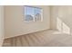 An empty bedroom with neutral carpet and a bright window looking out at the neighborhood at 638 W Nido Ave, Mesa, AZ 85210