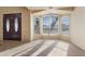 Inviting living room with a bay window, carpet flooring, and double doors leading to the foyer at 638 W Nido Ave, Mesa, AZ 85210