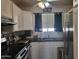 Galley kitchen with white cabinets, black countertops, and stainless steel appliances at 720 N 82Nd St # E210, Scottsdale, AZ 85257