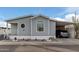 Gray manufactured home with carport, landscaping, and For Sale sign at 7807 E Main St # Cc-106, Mesa, AZ 85207