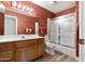 Bathroom with wood cabinets, a shower/tub combo, and wood floors at 8309 E Navarro Ave, Mesa, AZ 85209