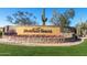 Inviting entrance to Mountain Bridge with stone signage, beautiful flowers, and lush greenery at 8729 E Indigo St, Mesa, AZ 85207